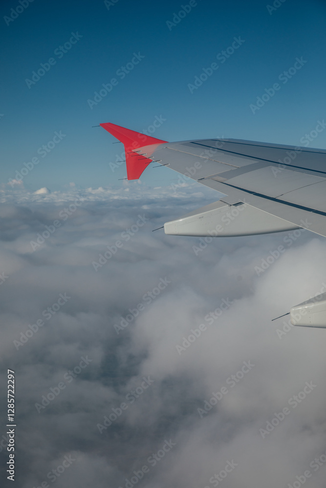 Fototapeta premium Airplane wings against blue sky background with clouds in flight