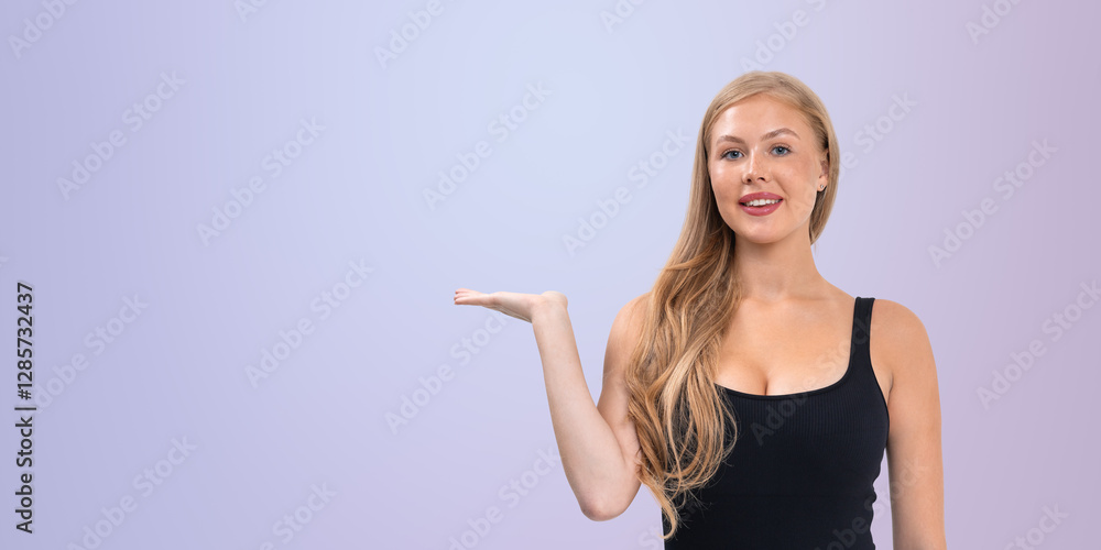 Fototapeta premium Smiling woman presenting with open palm gesture.