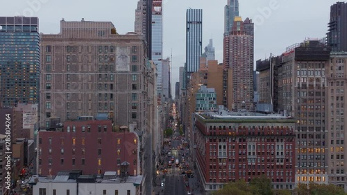Glowing Manhattan cityscape in Flatiron District capturing Fifth Avenue dynamism, architectural silhouettes, bustling traffic streams