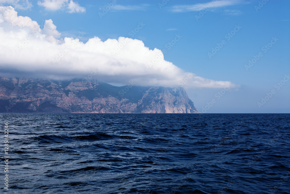 Majestic Coastal Cliff with Azure Ocean and White Clouds Under Clear Sky.. Majestic Coastal Cliff with Azure Ocean and White Clouds Under Clear Sky..