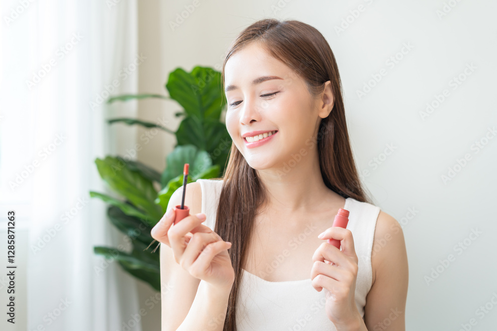 Skin care, beauty cosmetics concept, pretty asian young woman, girl make up face by applying red lipstick, lips balm on her mouth, looking at the mirror at home. Female look with natural fashion style Skin care, beauty cosmetics concept, pretty asian young woman, girl make up face by applying red lipstick, lips balm on her mouth, looking at the mirror at home. Female look with natural fashion style