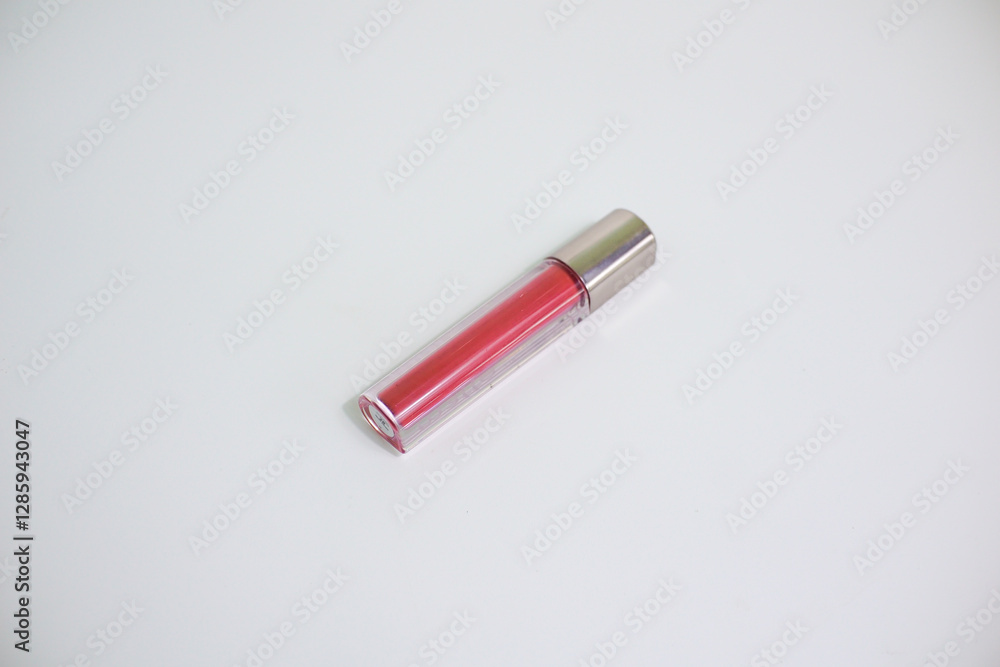 Red lip gloss in elegant glass bottle with shiny lid, container with brush isolated on white background, red lipstick Red lip gloss in elegant glass bottle with shiny lid, container with brush isolated on white background, red lipstick
