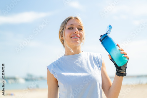 Fototapeta Naklejka Na Ścianę i Meble -  Young blonde woman at outdoors doing sport with a bottle of water
