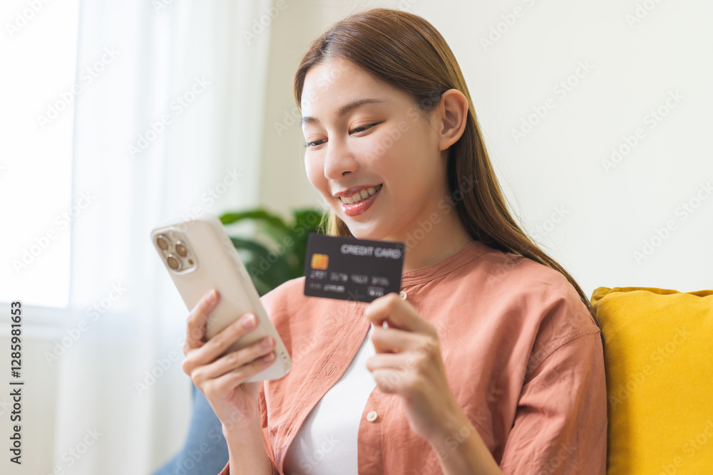 Bill pay, shopping order online internet, cute asian young woman hand holding credit card and mobile smart phone on sofa at home, female using banking service to secure payment with purchase on store. Bill pay, shopping order online internet, cute asian young woman hand holding credit card and mobile smart phone on sofa at home, female using banking service to secure payment with purchase on store.