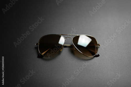 metal sunglasses with gold frames on a black background