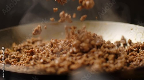 Juicy seasoned ground beef sizzling in a hot frying pan