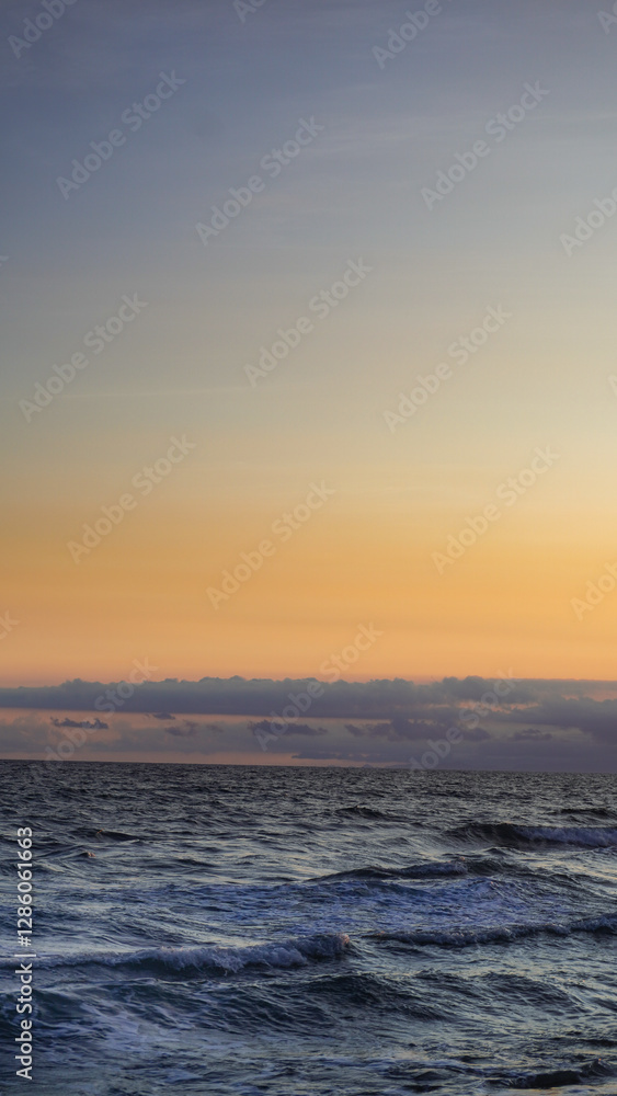 Serene ocean waves at sunset with a golden sky and soft clouds. A tranquil seascape perfect for travel, nature, and relaxation themes. Serene ocean waves at sunset with a golden sky and soft clouds. A tranquil seascape perfect for travel, nature, and relaxation themes.
