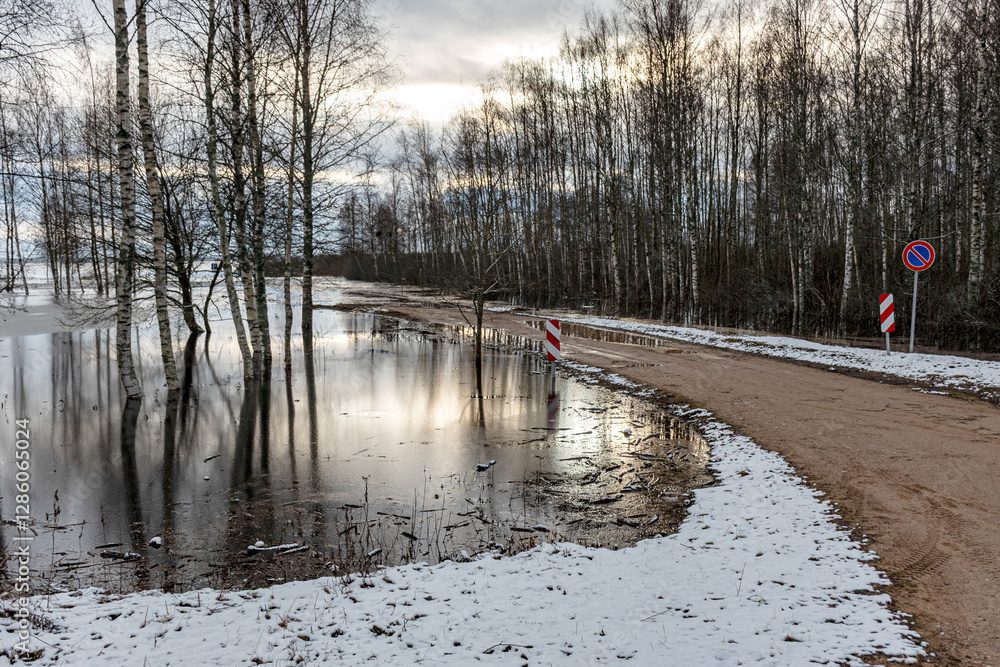 latvian winter landscape with flooded lake, thin and light ice in places, reflections