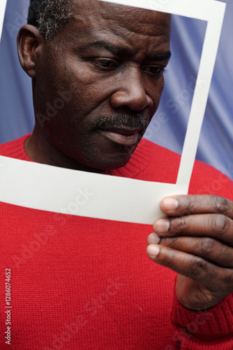 Holding Picture Frame While Wearing Red Sweater photo