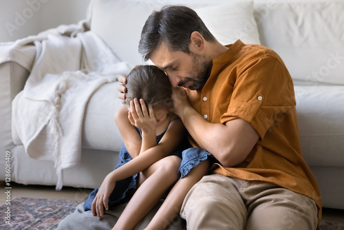 Loving father comforting little daughter, gives emotional support during challenging life moments, coping with hard period of life, going through relative death, embracing, sit close together on floor