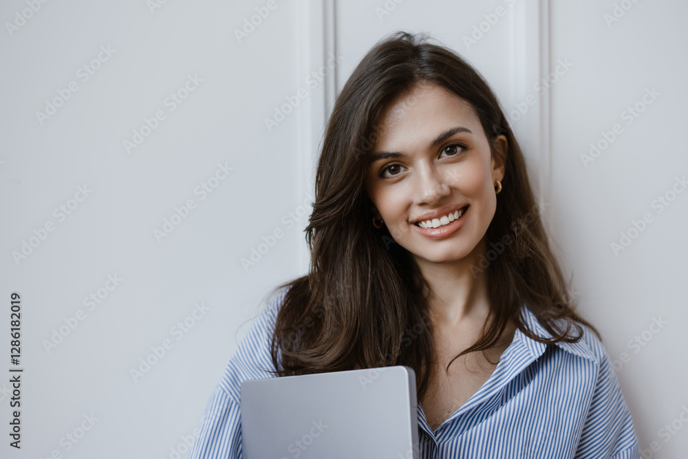 Corporate shot of a woman smiling and holding her laptop. Corporate shot of a woman smiling and holding her laptop.