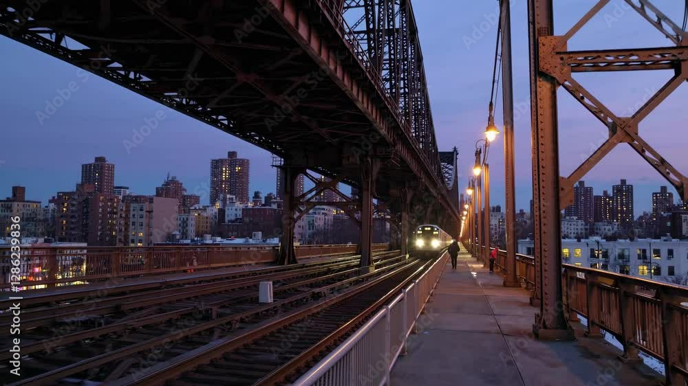 Urban video scene capturing a low-angle view of a bridge at dusk, highlighting industrial architecture against a city skyline backdrop. Urban video scene capturing a low-angle view of a bridge at dusk, highlighting industrial architecture against a city skyline backdrop.