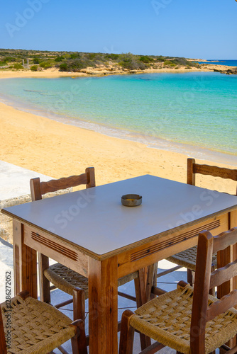 Obraz na płótnie A table with chairs overlooking Finikas beach on Ano Koufonisi island w salonie