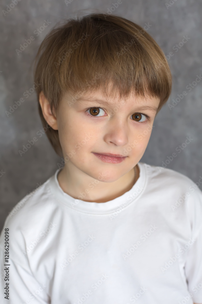 A handsome blond boy with big brown eyes wearing a white T-shirt A handsome blond boy with big brown eyes wearing a white T-shirt