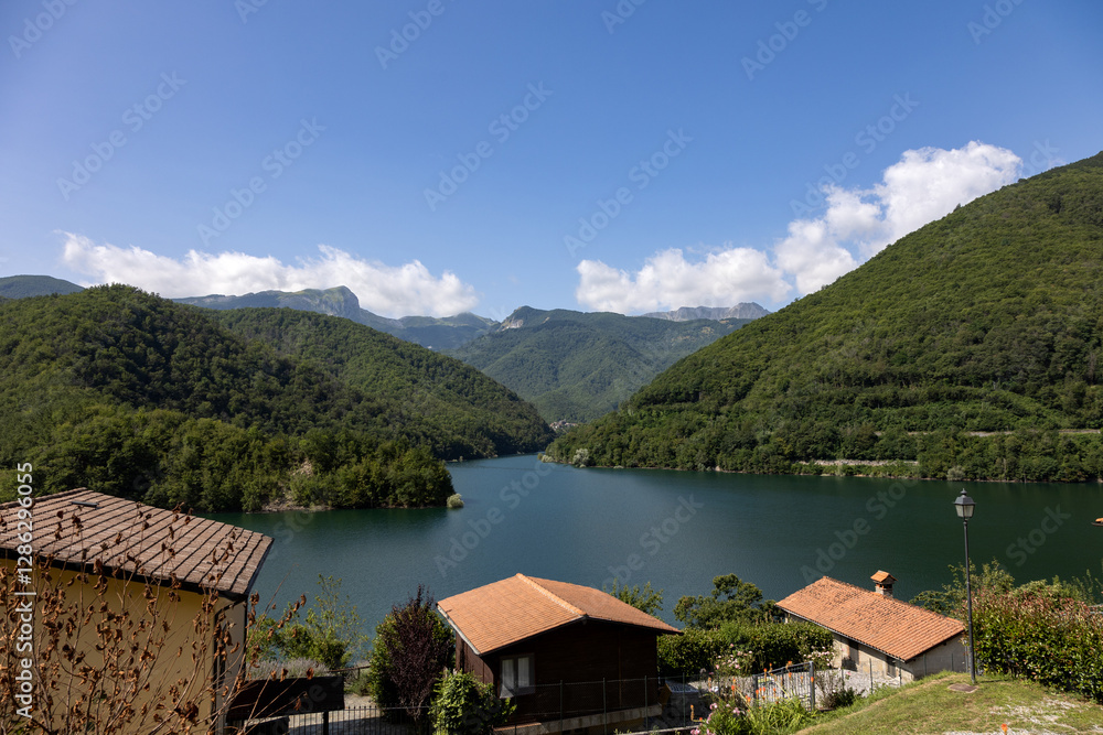Fototapeta premium Lake Vagli conceals the submerged village of Fabbriche di Careggine in Tuscany Italy offering a mysterious underwater heritage amid mountains picturesque hillside views and hidden cultural history