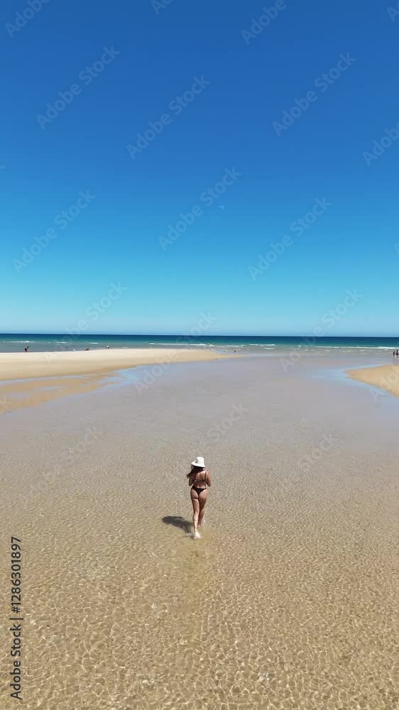 Woman at the beach in Ria Formosa, Algarve, Portugal, enjoying the calm waters on a sunny day. Woman at the beach in Ria Formosa, Algarve, Portugal, enjoying the calm waters on a sunny day.
