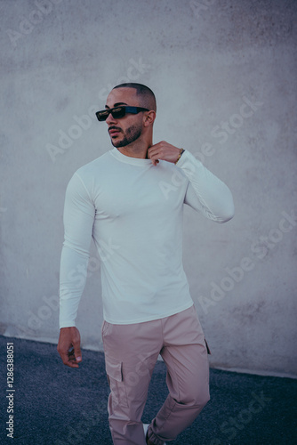 Obraz na płótnie Chico joven tatuado posando con ropa actual en la calle w salonie