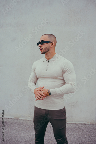 Obraz na płótnie Chico joven tatuado posando con ropa actual en la calle w salonie