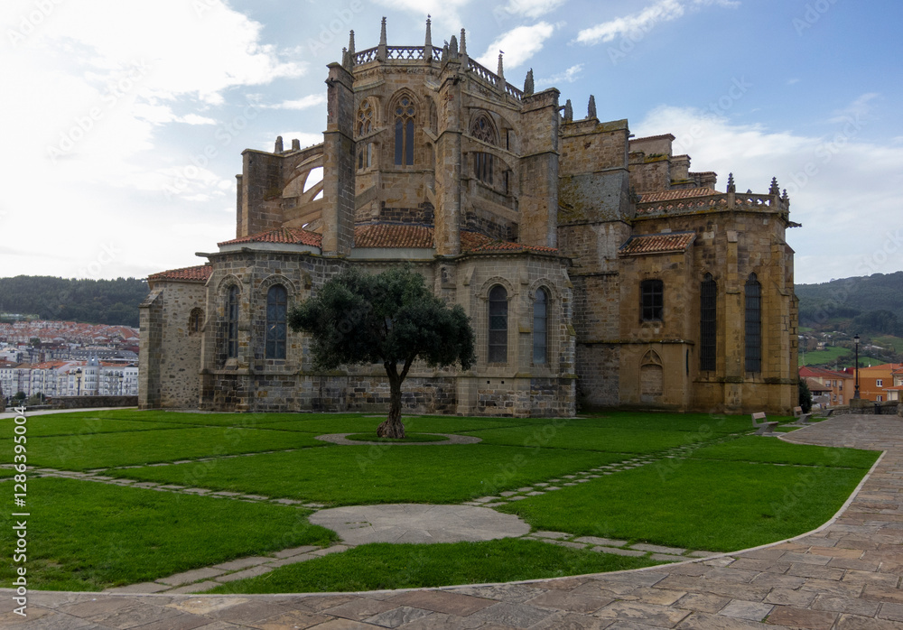 Fototapeta premium Detail plan of the impressive church of Santa María de la Asunción located in the touristic village of Cantabria by the sea and surrounded by trees.