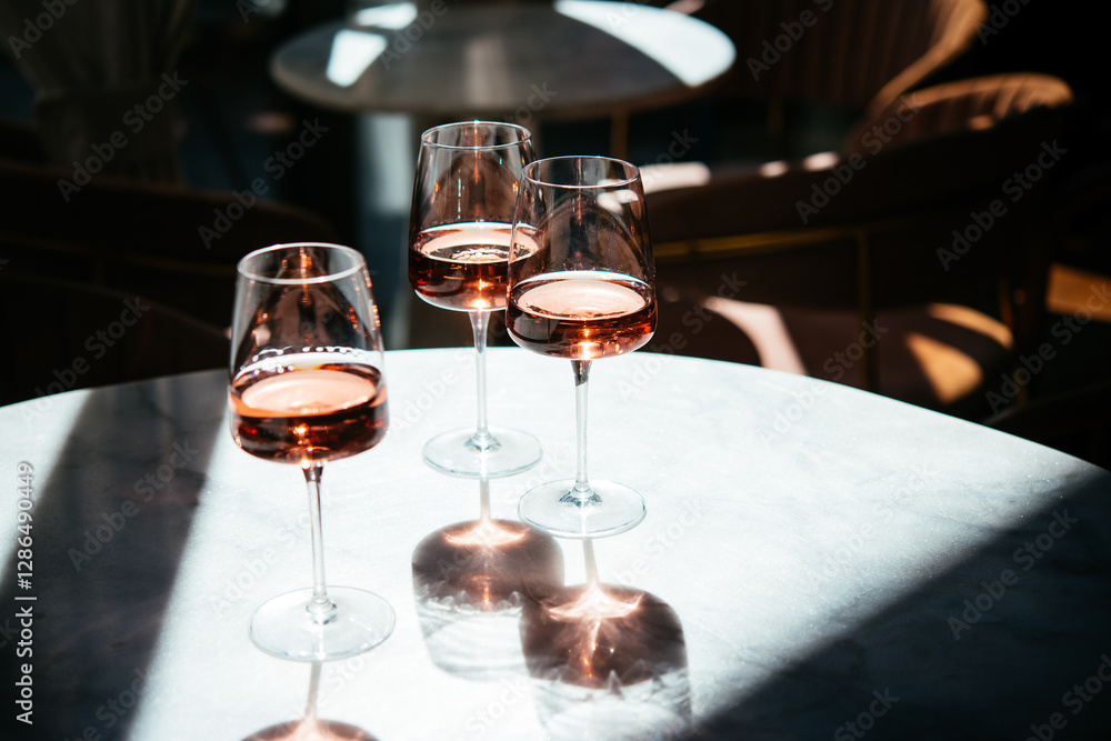 Glasses of rose wine seen in summer sunshine during a wine tasting in a bar or restaurant.