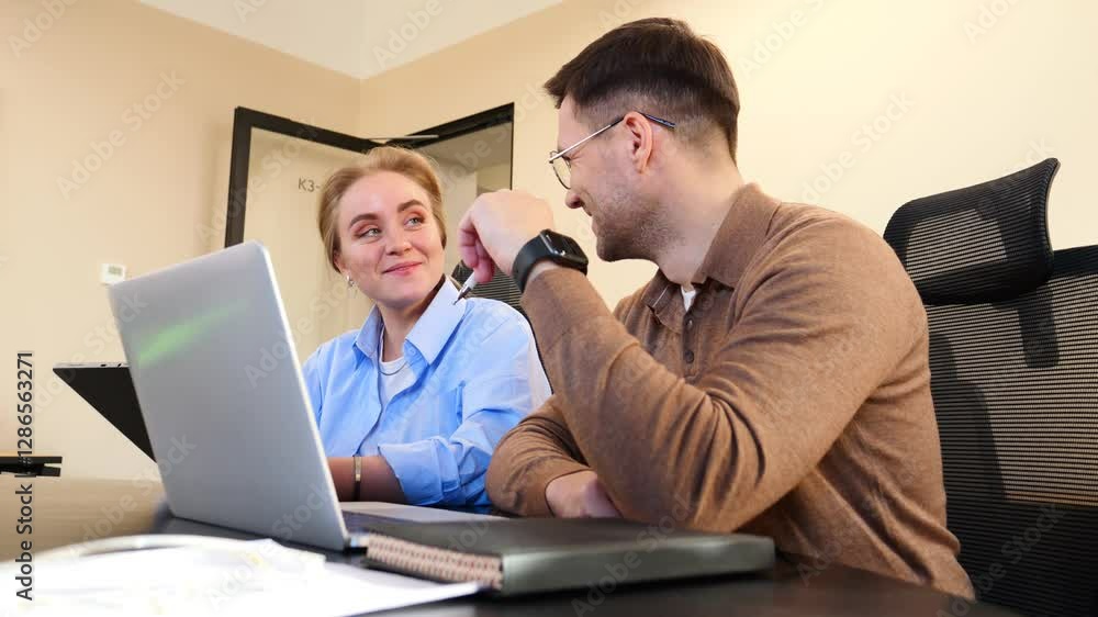 Two colleagues collaborate in a modern office setting while working on a laptop together Two colleagues collaborate in a modern office setting while working on a laptop together