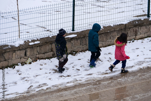 It snowed and the little friend kids are walking on the snow,