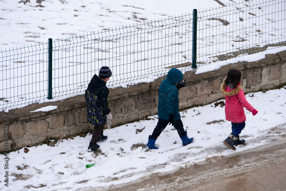 It snowed and the little friend kids are walking on the snow,