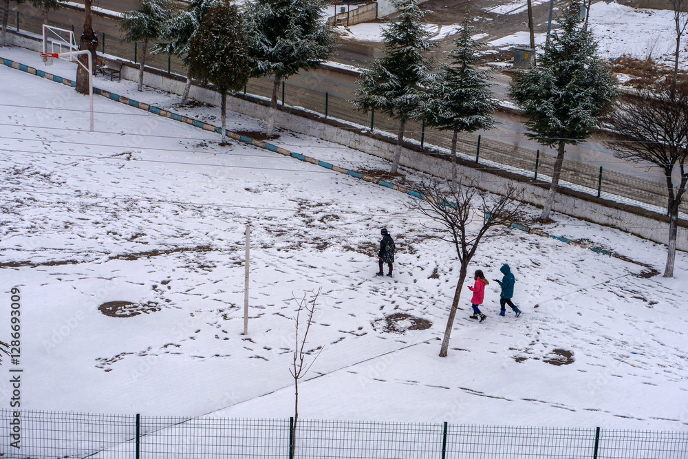 It snowed and the little friend kids are walking on the snow,
