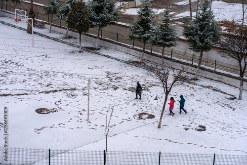 Obraz na płótnie It snowed and the little friend kids are walking on the snow, w salonie