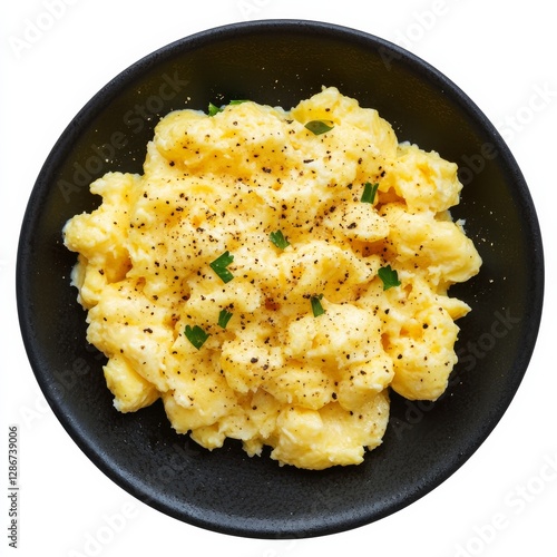 Delicious scrambled eggs with pepper and parsley on a black plate, perfect for a quick and tasty breakfast or brunch.