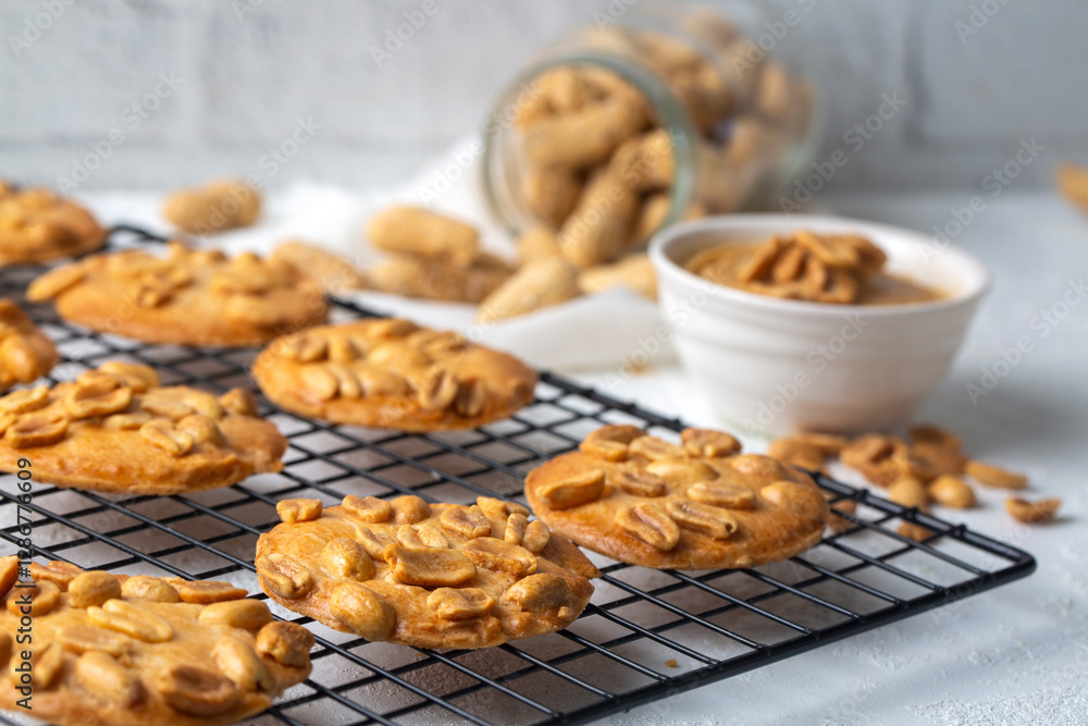 Tasty peanut cookies and butter on beige background