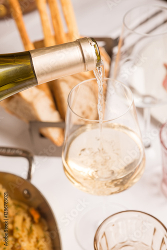 waiter pours white wine at restaurant