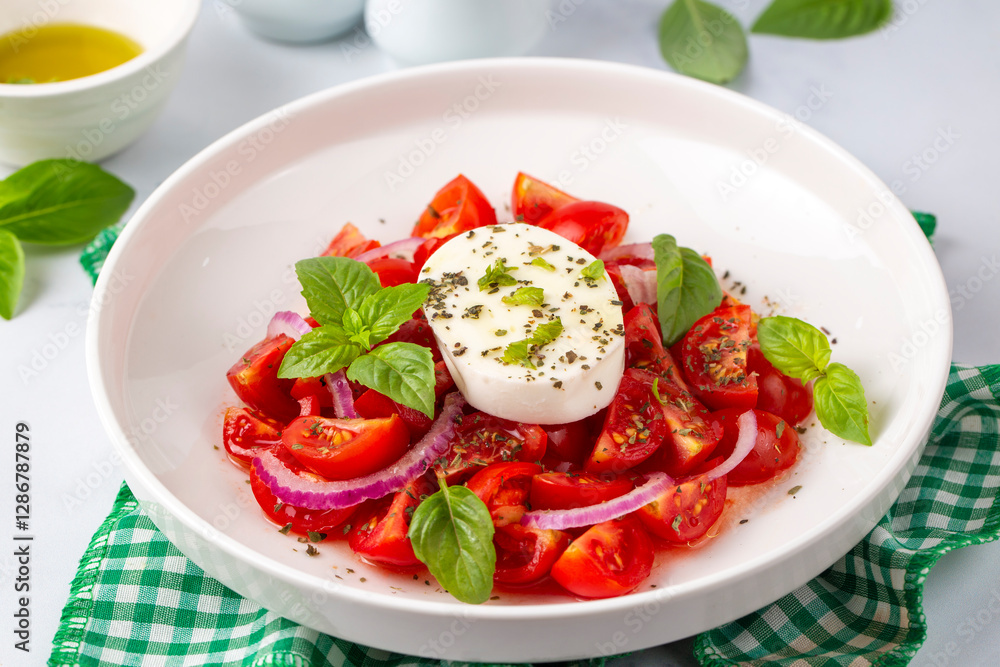 Italian caprese salad with sliced tomatoes, mozzarella, basil, olive oil