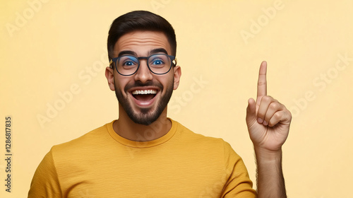 Excited man raising index finger having idea on yellow background