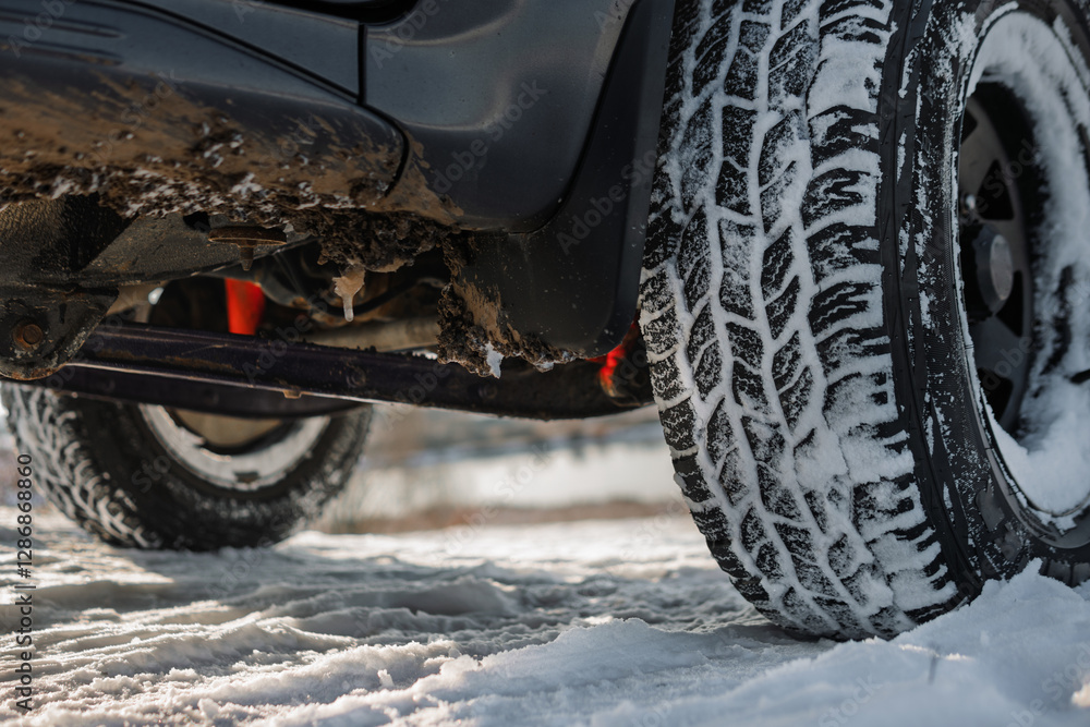Closeup of all-terrain tire and wheel of dirty 4x4 SUV car or truck - winter travel and recreation concept. Protector, tire pattern