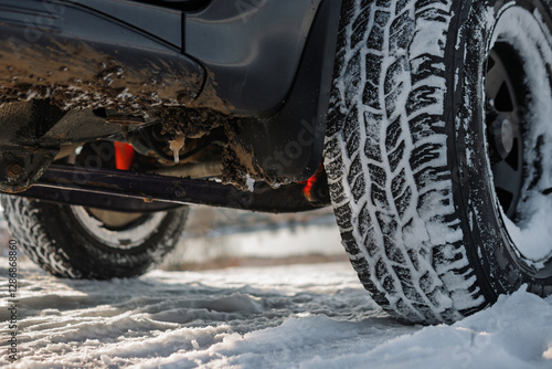 Obraz na płótnie Closeup of all-terrain tire and wheel of dirty 4x4 SUV car or truck - winter travel and recreation concept. Protector, tire pattern w salonie