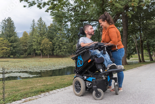 Man, an electric wheelchair user in the warm embrace of his wife, a couple enjoying and showing their affection. Disability and love concept.