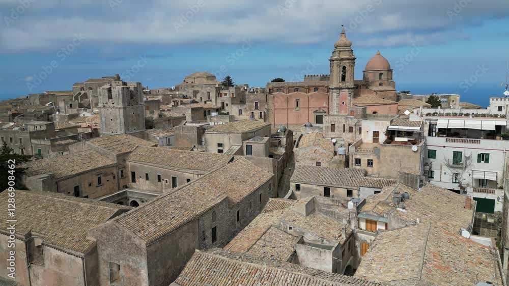 Flying over classic rooftops of historic homes towards church in hilltop village of Erice, heritage and tourism in Sicily Italy
Flying over classic rooftops of historic homes towards church in hilltop village of Erice, heritage and tourism in Sicily Italy