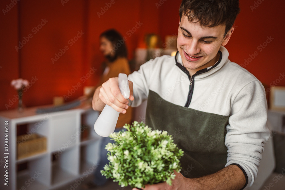 young man gardener use spray for hydration home plant young man gardener use spray for hydration home plant