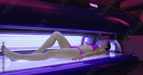 Woman relaxing while tanning in solarium getting uv light therapy