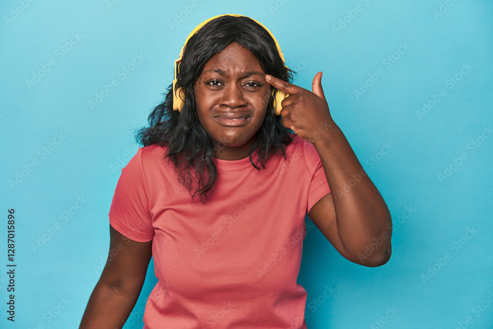 Naklejka premium Curvy lady enjoying music in studio showing a disappointment gesture with forefinger.