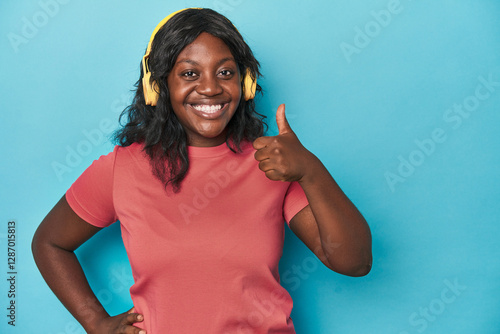 Foto Curvy lady enjoying music in studio smiling and raising thumb up