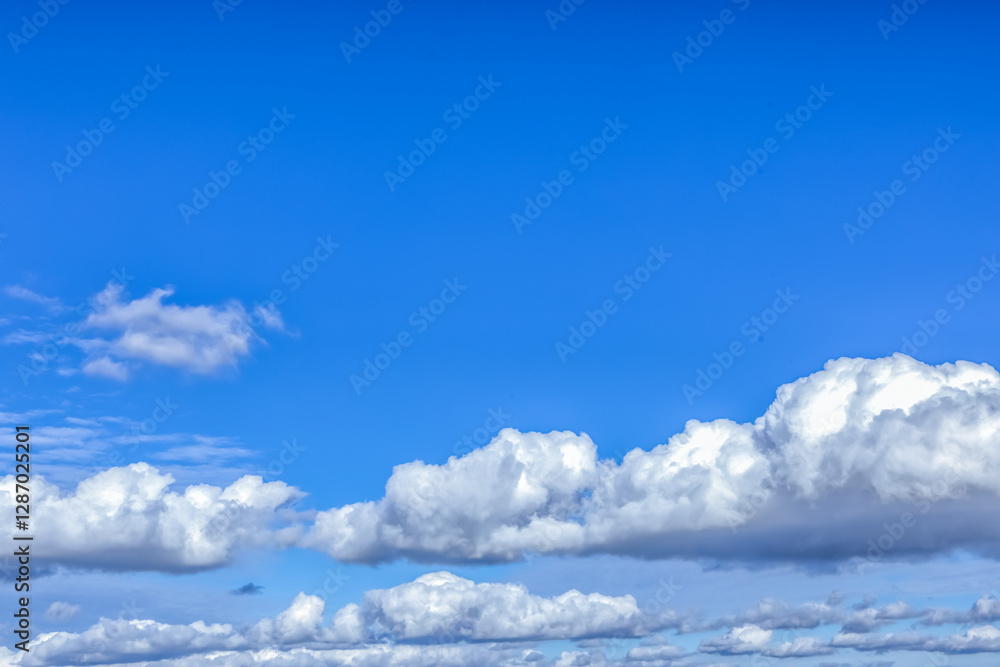 The sky is endless and deep blue, with cotton-like clouds scattered. Some clouds are light and airy, while others are dense, making the scene visually rich. The sky is endless and deep blue, with cotton-like clouds scattered. Some clouds are light and airy, while others are dense, making the scene visually rich.