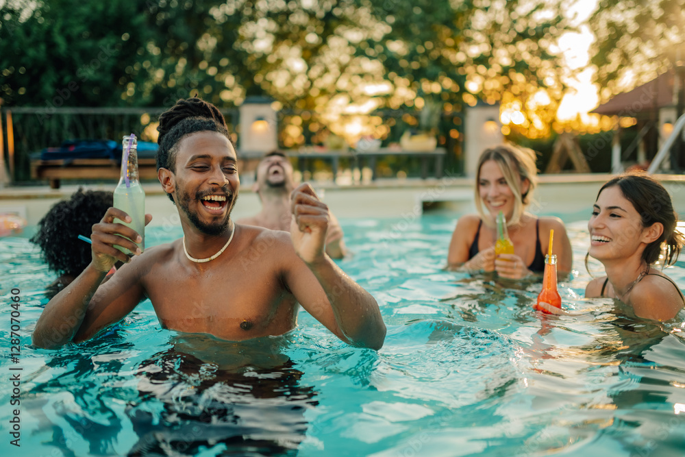 Friends enjoying drinks and laughing in swimming pool at sunset party Friends enjoying drinks and laughing in swimming pool at sunset party