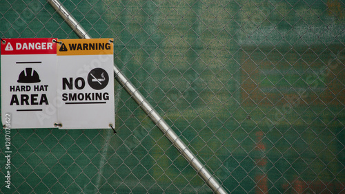 signs at a construction site. No smoking and you need a hardhat