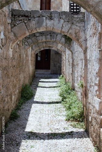 Cobblestone street of a medieval town with stone arches