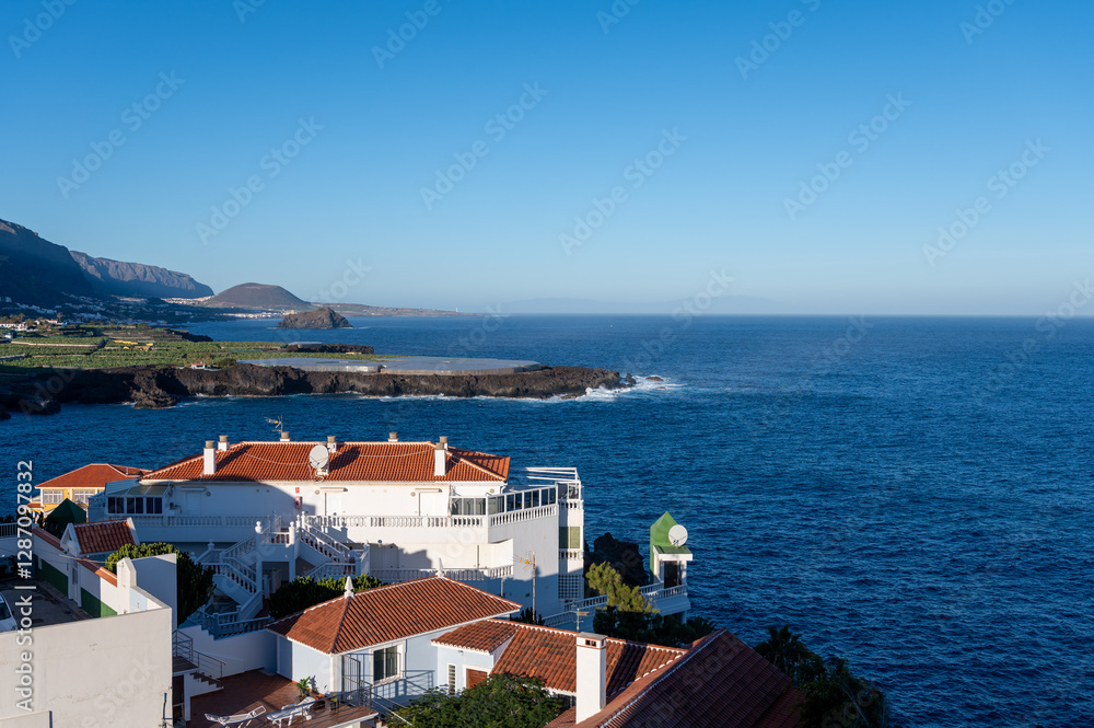 Fototapeta premium View on colonial old town Garachico, mountains, ocean, banana plantations, on Tenerife as seen from Playa San Marco, Canary islands, Spain in winter