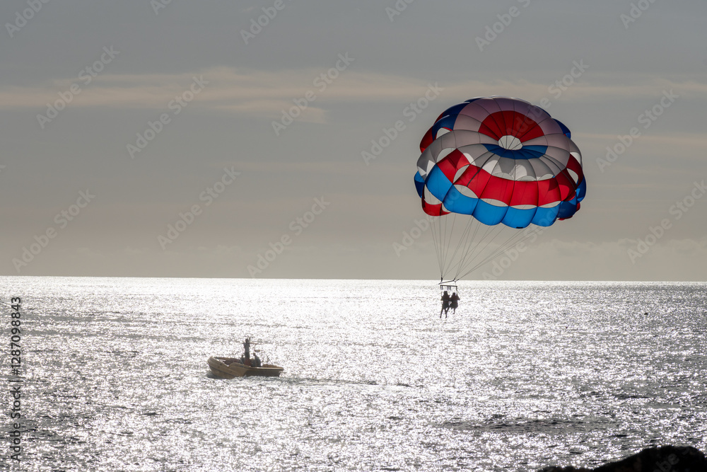 Parasailing or parascending recreational water sport with boat on Tenerife, Costa de Adeje, adventure for tourists Parasailing or parascending recreational water sport with boat on Tenerife, Costa de Adeje, adventure for tourists