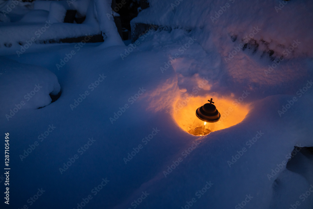 Candle on a cemetery, sinking in snow due to warmth. Sad reminder, remembrance of a person, slowly fading into cold snow. Concept of afterglow of a person