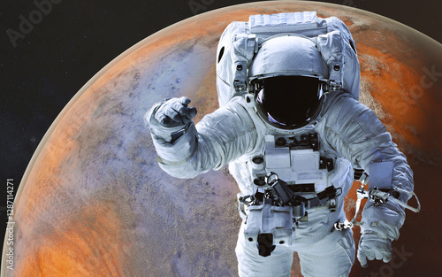 Obraz na płótnie Space astronaut in a white spacesuit floating in space during a spacewalk, in a front of red fiction planet with atmosphere visible below and a starry space background. Elements of 3D rendered illustr w salonie